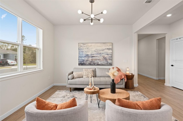 living room featuring a chandelier and light hardwood / wood-style flooring