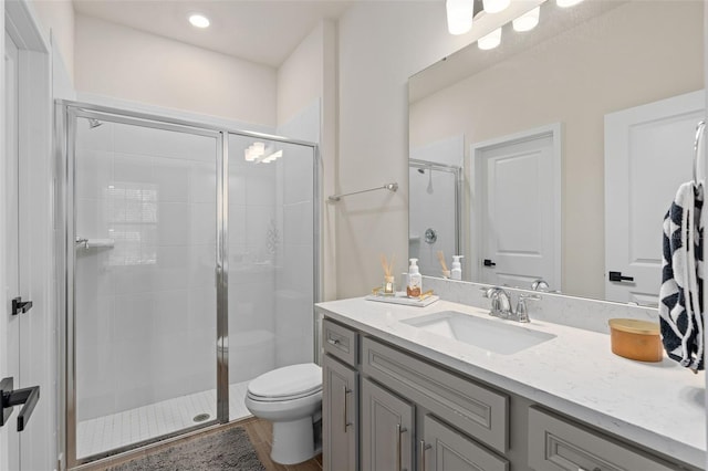 bathroom featuring walk in shower, vanity, toilet, and hardwood / wood-style floors