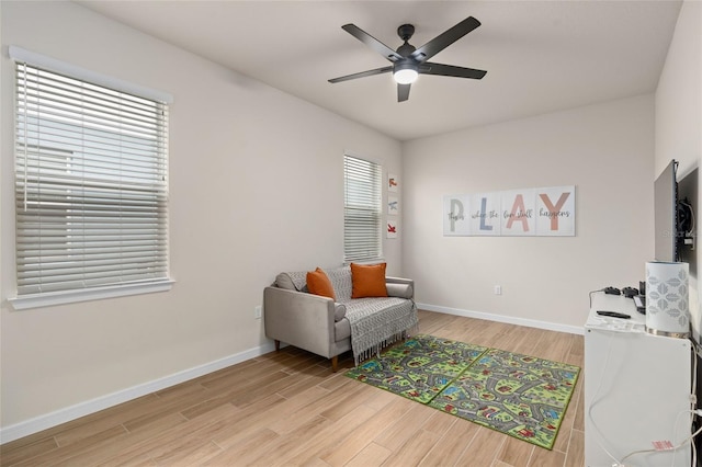 living area with ceiling fan and light wood-type flooring