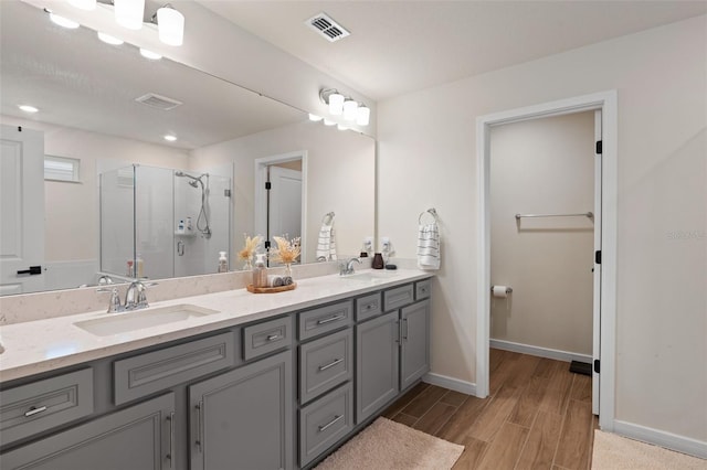 bathroom with a shower with door and vanity