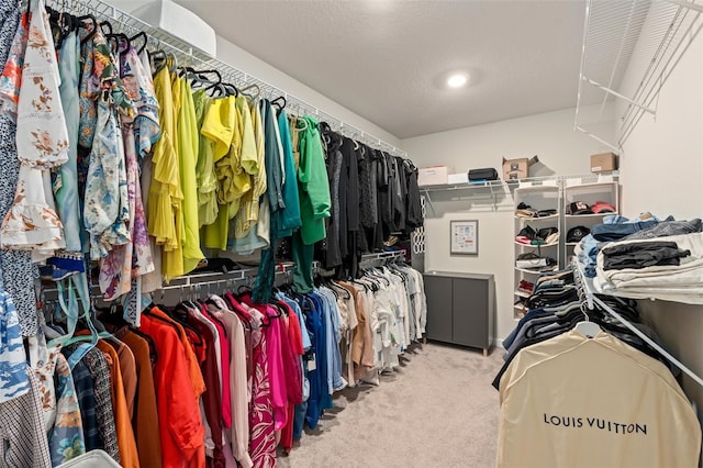 walk in closet featuring light colored carpet