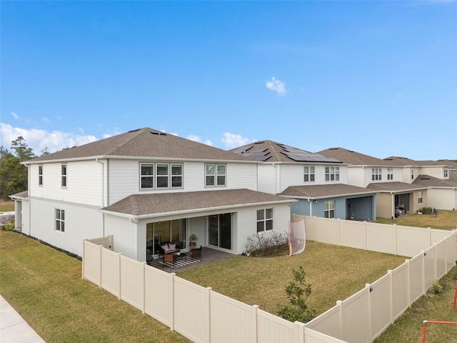 rear view of house with a patio and a lawn