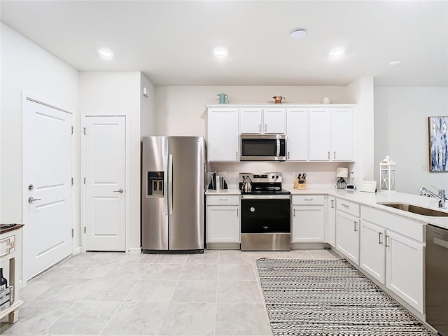 kitchen with sink, light tile patterned floors, white cabinets, and appliances with stainless steel finishes