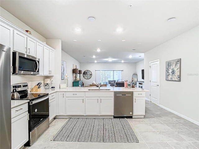 kitchen featuring stainless steel appliances, kitchen peninsula, and white cabinets