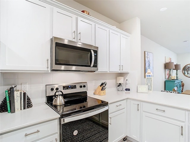 kitchen featuring stainless steel appliances, white cabinetry, and decorative backsplash