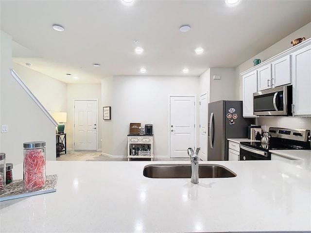 kitchen featuring appliances with stainless steel finishes, sink, and white cabinets