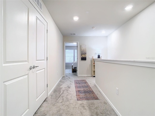 corridor featuring light colored carpet