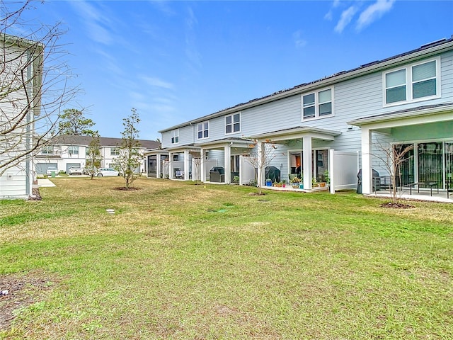 rear view of property featuring a lawn