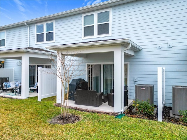 rear view of property with a yard, central AC, outdoor lounge area, and a patio area