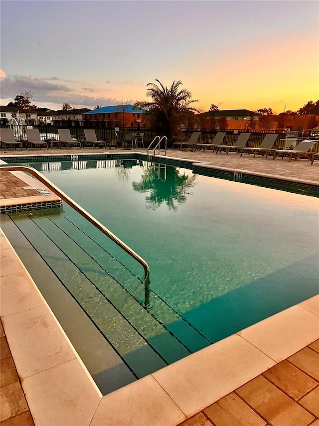 pool at dusk with a patio area