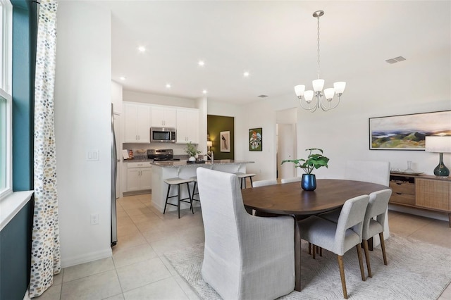 tiled dining area with a chandelier