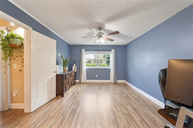 unfurnished office with ceiling fan, crown molding, a textured ceiling, and light hardwood / wood-style flooring