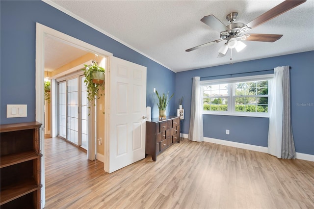 interior space featuring ceiling fan, a textured ceiling, and light wood-type flooring