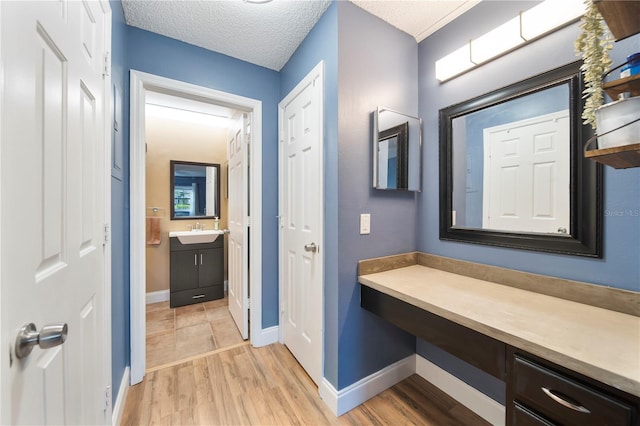 bathroom featuring vanity, hardwood / wood-style flooring, and a textured ceiling