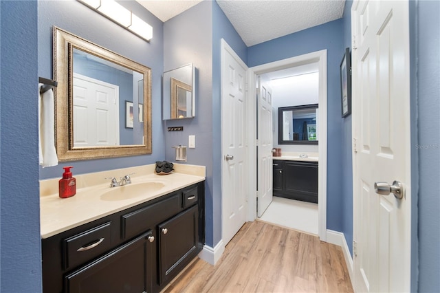 bathroom featuring vanity, hardwood / wood-style flooring, and a textured ceiling