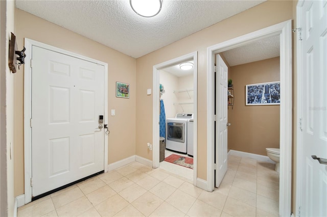 foyer with washer / clothes dryer and a textured ceiling