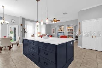 kitchen featuring blue cabinetry, decorative light fixtures, and a center island