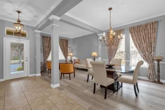 dining space with an inviting chandelier, a healthy amount of sunlight, and beam ceiling