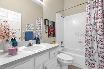 full bathroom featuring vanity, shower / bath combination with curtain, and toilet