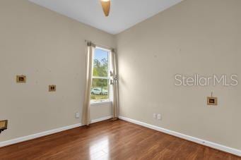 unfurnished room with dark hardwood / wood-style floors and ceiling fan