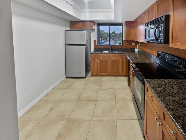 kitchen featuring sink, a tray ceiling, black appliances, and dark stone counters