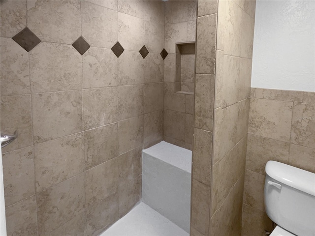 bathroom featuring toilet and tiled shower