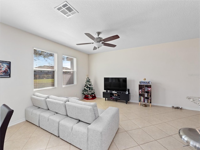 tiled living room featuring ceiling fan and a textured ceiling