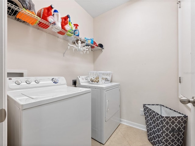 clothes washing area with separate washer and dryer and light tile patterned floors