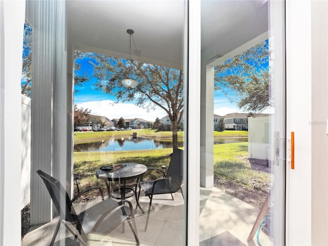 doorway with a water view and tile patterned floors