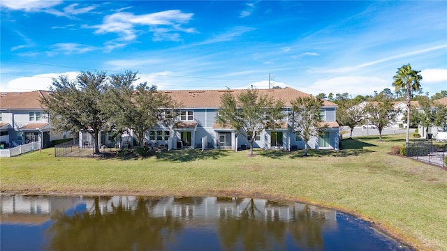 back of house featuring a water view and a yard