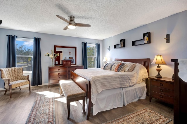 bedroom featuring a textured ceiling, wood-type flooring, and ceiling fan