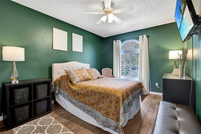 bedroom featuring hardwood / wood-style floors, a textured ceiling, and ceiling fan