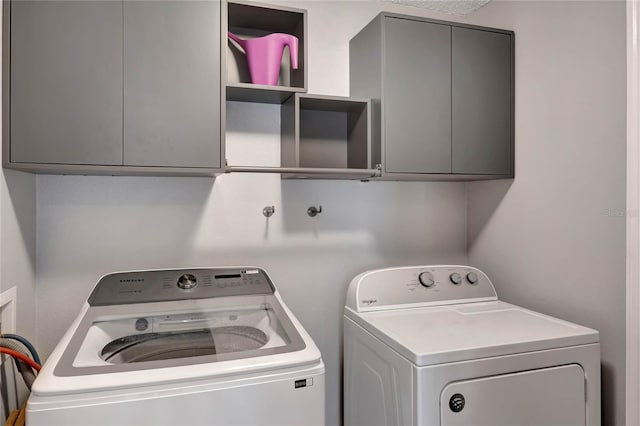 laundry area featuring cabinets and washing machine and clothes dryer