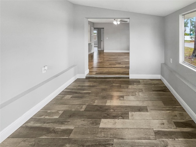 empty room with ceiling fan, dark wood-type flooring, and lofted ceiling