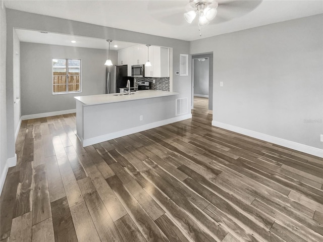 kitchen featuring white cabinetry, stainless steel appliances, decorative backsplash, hanging light fixtures, and kitchen peninsula