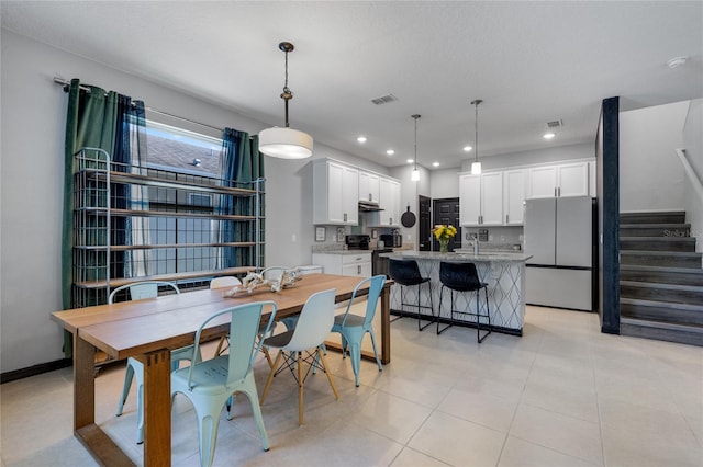 dining area featuring sink, a textured ceiling, and light tile patterned floors