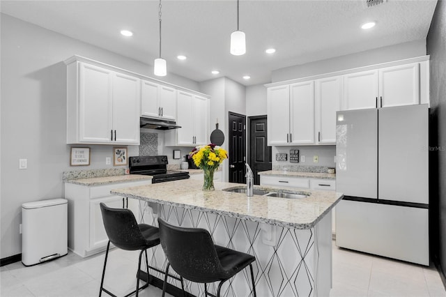 kitchen featuring sink, white cabinets, a kitchen bar, black / electric stove, and white fridge