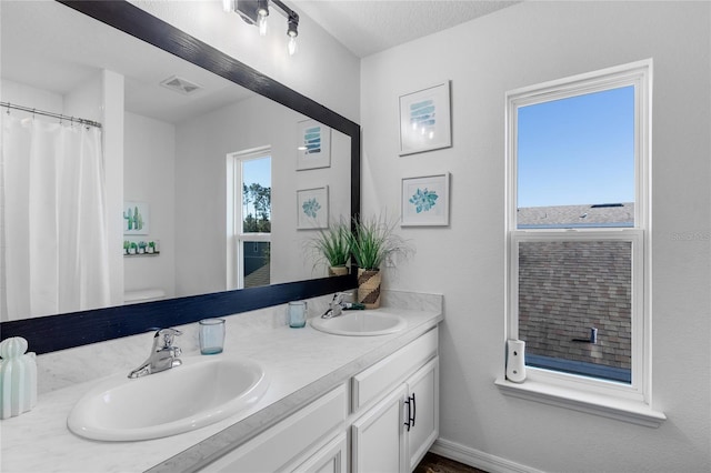 bathroom with vanity, a wealth of natural light, and toilet