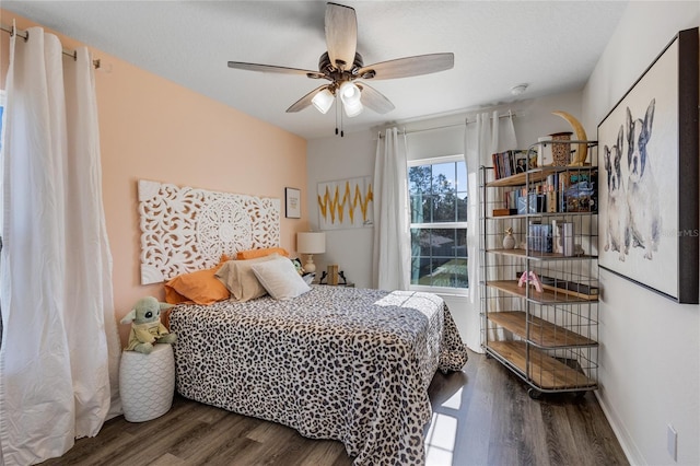 bedroom with multiple windows, dark hardwood / wood-style flooring, and ceiling fan