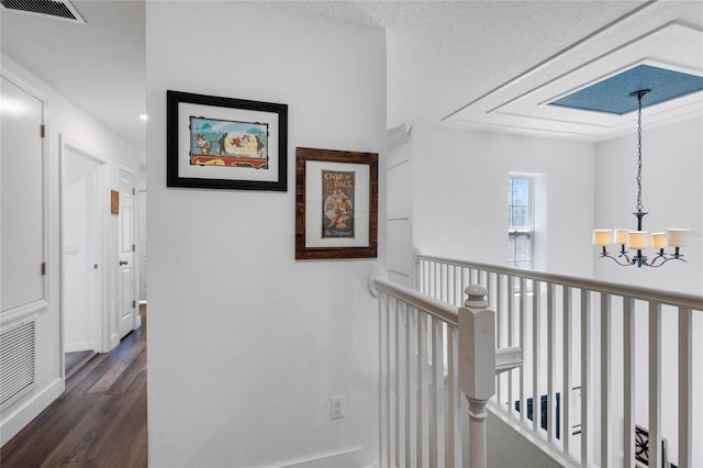 hallway with a notable chandelier and dark wood-type flooring