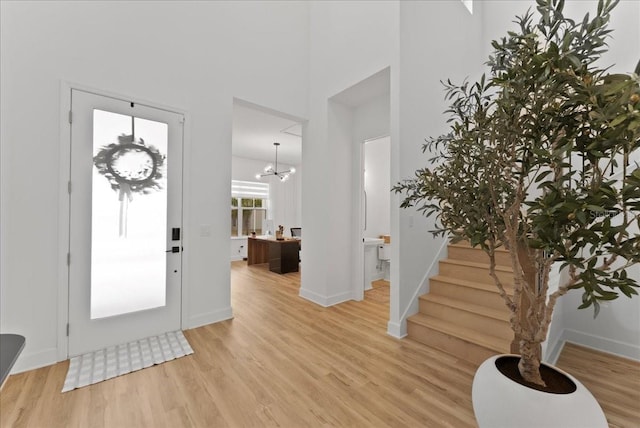 entryway with a towering ceiling and light hardwood / wood-style flooring