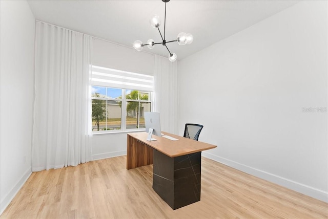 unfurnished office featuring light hardwood / wood-style flooring and an inviting chandelier