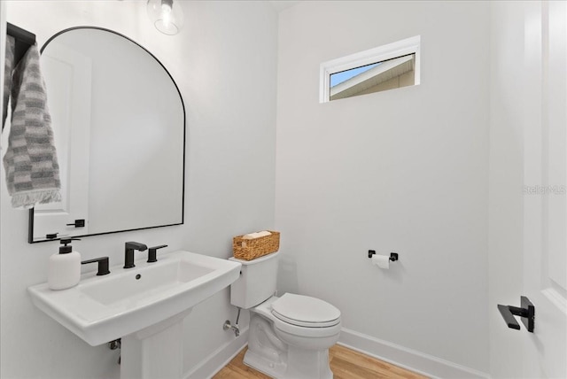 bathroom with hardwood / wood-style flooring, sink, and toilet