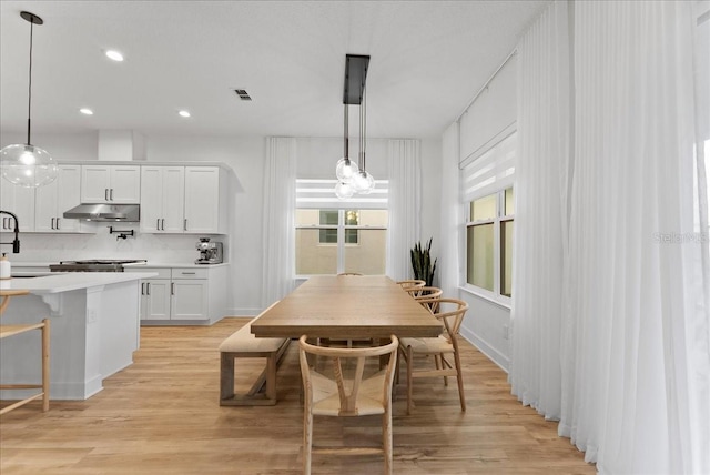 dining space with light hardwood / wood-style floors and sink