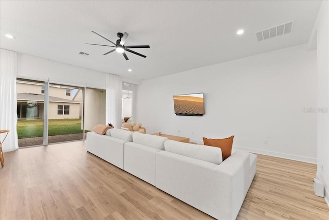 living room featuring ceiling fan and light hardwood / wood-style floors