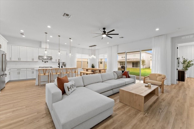 living room featuring ceiling fan and light hardwood / wood-style flooring