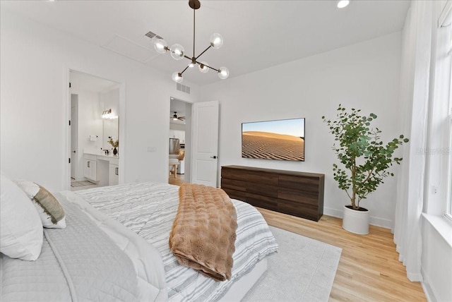 bedroom with light hardwood / wood-style flooring and ensuite bath