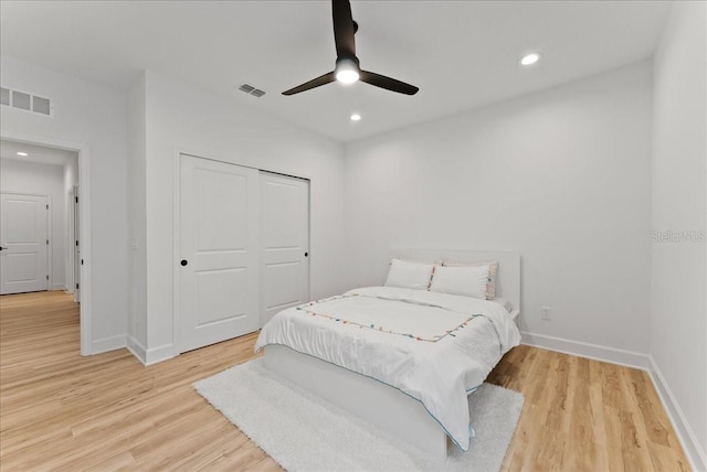 bedroom featuring light hardwood / wood-style floors, a closet, and ceiling fan