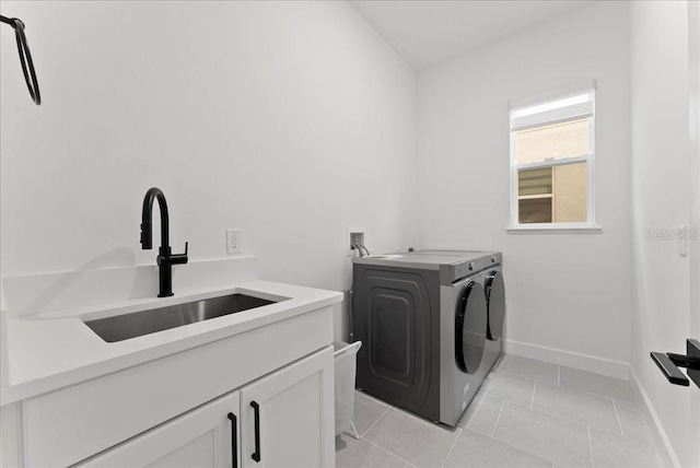 laundry room with cabinets, sink, light tile patterned floors, and washer and dryer