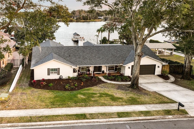 single story home featuring a garage, a water view, and a front lawn